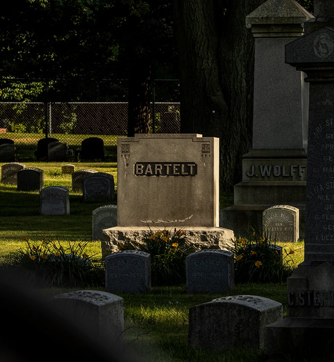 Photo of raised upright headstone with the family name 